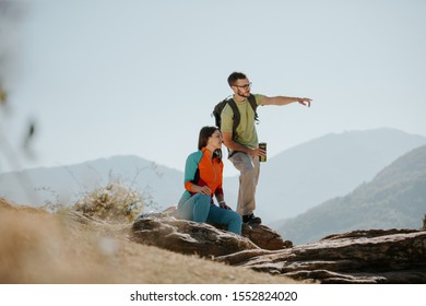 Couple Hikers Taking A Break On The Mountaintop