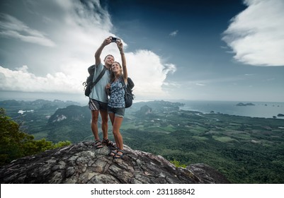 Couple Of Hikers Taking Selfie From Top Of The Mountain With Valley View On The Background