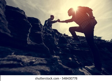 Couple hiking help each other silhouette in mountains with sunlight - Powered by Shutterstock