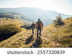 Couple hiking on a scenic mountain trail with backpacks and trekking poles