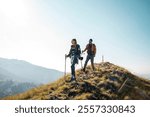 Couple hiking on a scenic mountain trail with backpacks and trekking poles