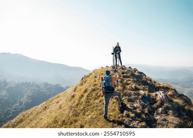 Couple hiking on a scenic mountain trail with backpacks and trekking poles - Powered by Shutterstock