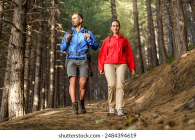 Couple hiking together in the forest - outdoor adventure, enjoying nature, active lifestyle, walking on nature trail, bonding time - woodland setting. - Powered by Shutterstock