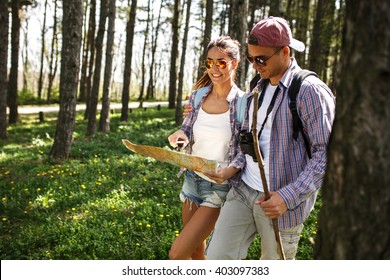Couple hiking trough forest. Using map to get good direction.