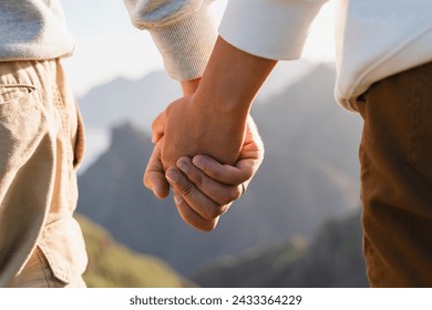 Couple hold hands in mountains nature. Friends or lovers holding hands while walking outdoors. - Powered by Shutterstock