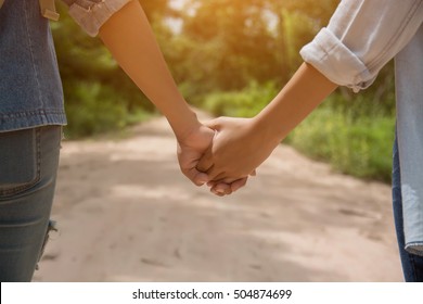 Couple Holding Hand In The Park In The Sunset