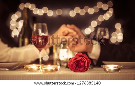Couple holding hands having a romantic dinner date, Valentines day, anniversary concepts.  