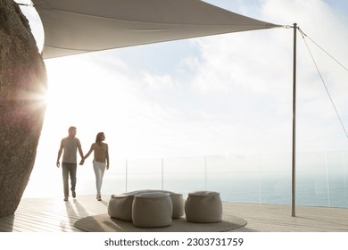 Couple holding hands on modern balcony - Powered by Shutterstock