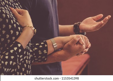 A Couple Holding Hands Praying.