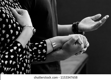 A Couple Holding Hands Praying. Black And White