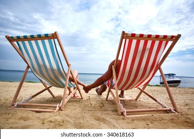Couple holding hands and sunbathing on the beach