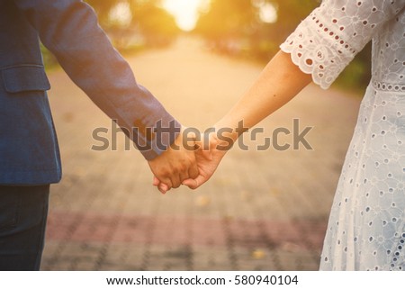  couple holding hands with sunlight  in park