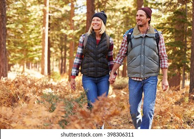 Couple holding hands walking in a forest, California, USA - Powered by Shutterstock