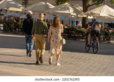 A Couple Holding Hands Walking Through The Old Town Outdoors On A Sunny Summer Evening To The Umbrellas Of A Summer Restaurant, Traditional, Adult Couple, Tourists In Krakow, Close Relationship, Love