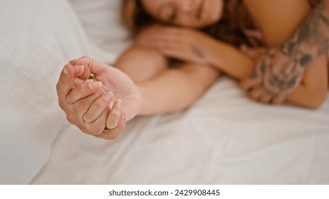 A couple holding hands while sleeping in a cozy bedroom, showcasing intimacy and affection. - Powered by Shutterstock