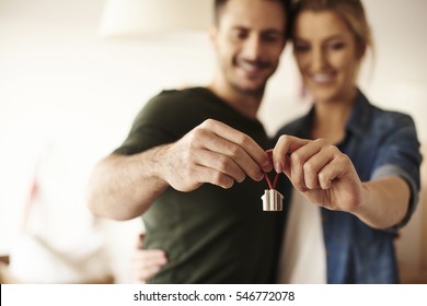 Couple holding key ring to their new house 