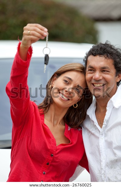 Couple holding\
up the keys of their brand new\
car