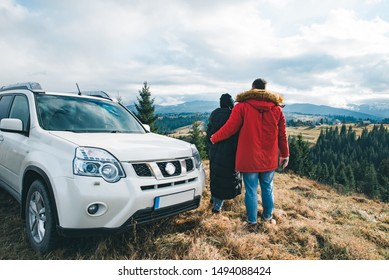 couple holding and looking at beautiful mountains view. car travel road trip. tourism concept