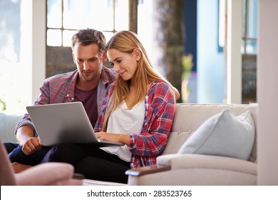Couple At Home In Lounge Using Laptop Computer