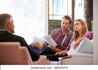 Couple At Home Meeting With Financial Advisor