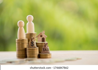 Couple and home model on rows of rising coins, US dollar bags on a table. Concept house or building or land value, property tax, local development tax depicts ad valorem tax on value of a property