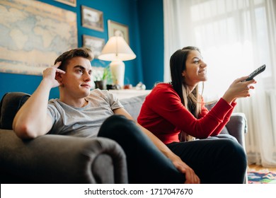 Couple At Home Watching TV.Remote Control Fight Won By Girlfriend.Boyfriend Bored By TV Program.Watching Her Favorite Show/film.Chick Flick Movie.Binge Watching Television.Relationship Home Problems.