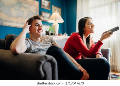 Couple At Home Watching TV.Remote Control Fight Won By Girlfriend.Boyfriend Bored By TV Program.Watching Her Favorite Show/film.Chick Flick Movie.Binge Watching Television.Relationship Home Problems.