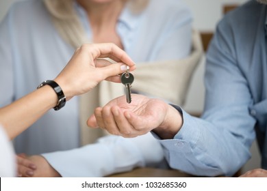 Couple of homeowners getting key to new house apartment from realtor, happy real estate owners make purchase deal, family mortgage investment and buying property concept, close up view of hands - Powered by Shutterstock