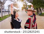 couple of huasos dancing Chilean cueca in the city square, Fiestas Patrias celebration 