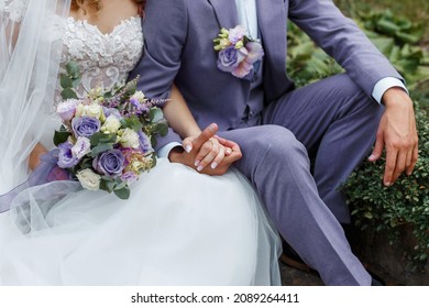 Couple hugging on their wedding. Trendy color of the year 2022 in wedding. Bride holding bouquet and embracing groom in Very Peri suit.