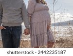 Couple Husband and Wife Expecting Baby Maternity Photos Christian Mormon Pretty Dress Holding Hands