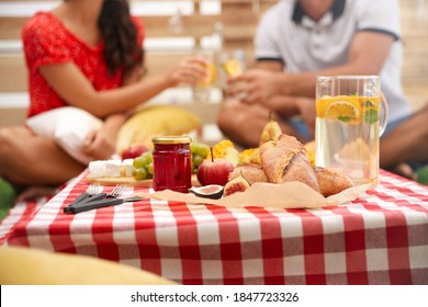 Couple Imitating Picnic At Home, Focus On Tasty Food