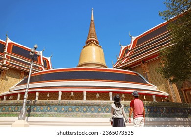 Couple Impressed by a 43 Meters High Gilded Pagoda and the Iconic Circular Gallery of Wat Ratchabophit Buddhist Temple, Bangkok, Thailand - Powered by Shutterstock