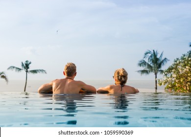 Couple In Infinity Pool Looking At Horizon