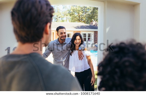 Couple inviting friend at there new\
house. People attending friend\'s housewarming\
party.