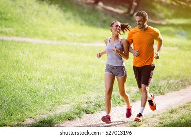 Couple jogging and running outdoors in nature - Shutterstock ID 527013196