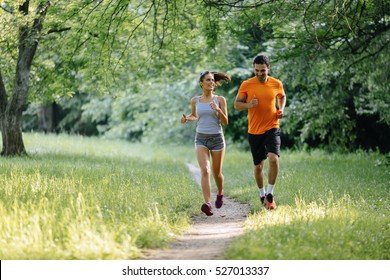 Couple Jogging And Running Outdoors In Nature