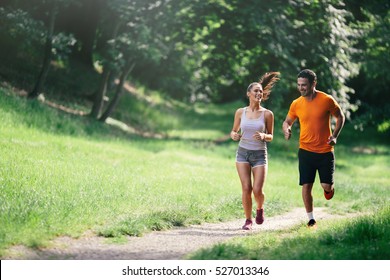 Couple jogging and running outdoors in nature - Shutterstock ID 527013346