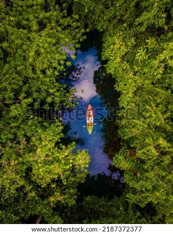 couple in a kayak in the jungle of Krabi Thailand, men and woman in kayak at a tropical jungle in Krabi mangrove forest.