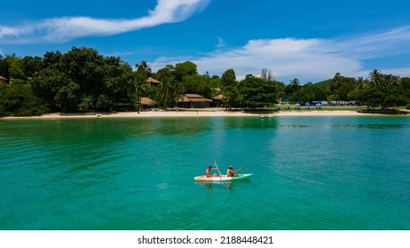 Couple In A Kayak In The Ocean Of Phuket Naka Island Thailand, Men And Woman In A Kayak At A Tropical Island With Palm Trees And Mangrove Forest. 