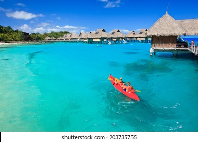 Couple Kayaking In The Blue Lagoon, Bora Bora, French Polynesia, South Pacific