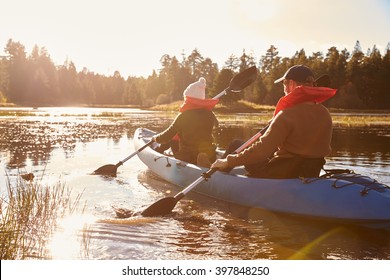 Couple kayaking on lake, back view, close-up