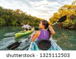 Couple kayaking together in mangrove river of the Keys, Florida, USA. Tourists kayakers touring the river of Islamorada.
