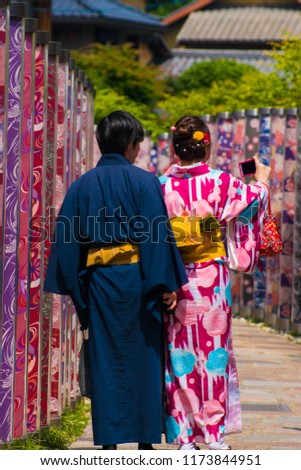 The couple in kimono are taking photos.