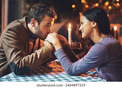 Couple, kiss and hands with romance on date in restaurant for anniversary, honeymoon and love with candle. People, happy and dinner with fine dining for support, trust and commitment in marriage - Powered by Shutterstock