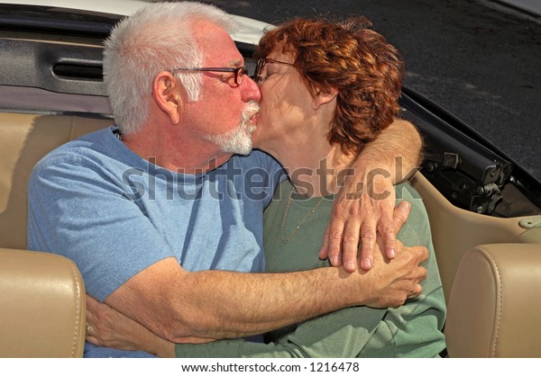 Couple kissing in back seat\
of car