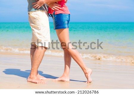 couple kissing at beach. legs view
