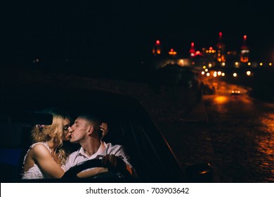 couple kissing in the car with a great old castle behind it