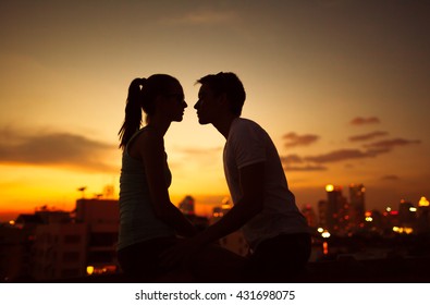 Couple kissing on a roof top.