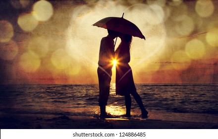 Couple kissing under umbrella at the beach in sunset. Photo in old image style. - Powered by Shutterstock